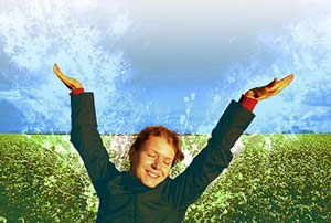 joyous girl in a field of grain with her arms up in the air