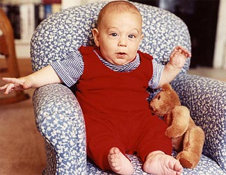 Renita's son Mikey in a little rocking chair due for a foot tickle