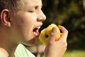 child biting into apple