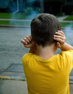 boy with hands over ears