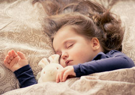 sleeping toddler holding bunny stuffed animal